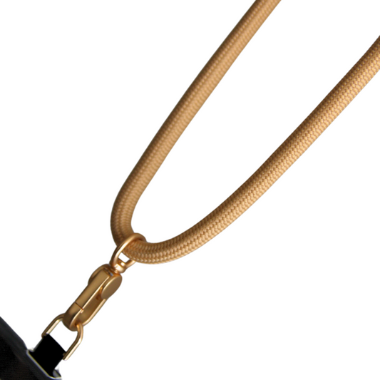 White background. In the front is beige coloured crossbody phone strap.