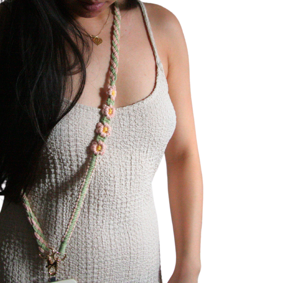Girl wearing green and pink crossbody phone strap with flowers.