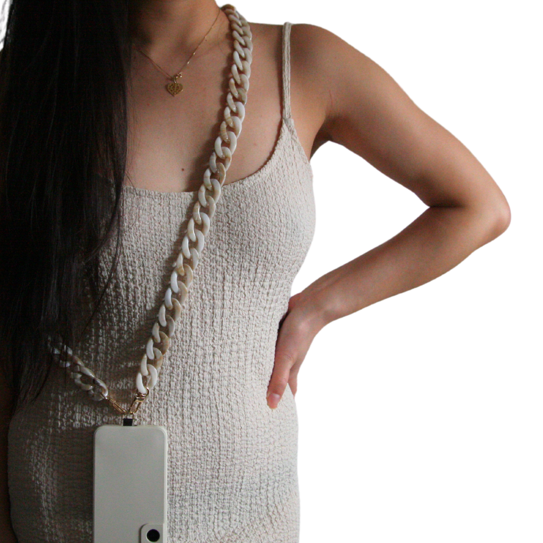 Girl posing, wearing white dress and wearing marble white crossbody phone strap.