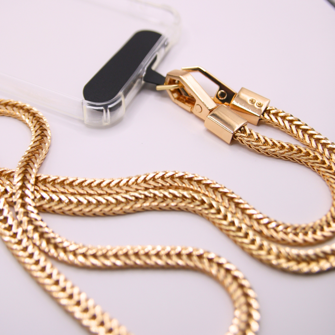 Detailled and focussed on the golden crossbody phone strap.