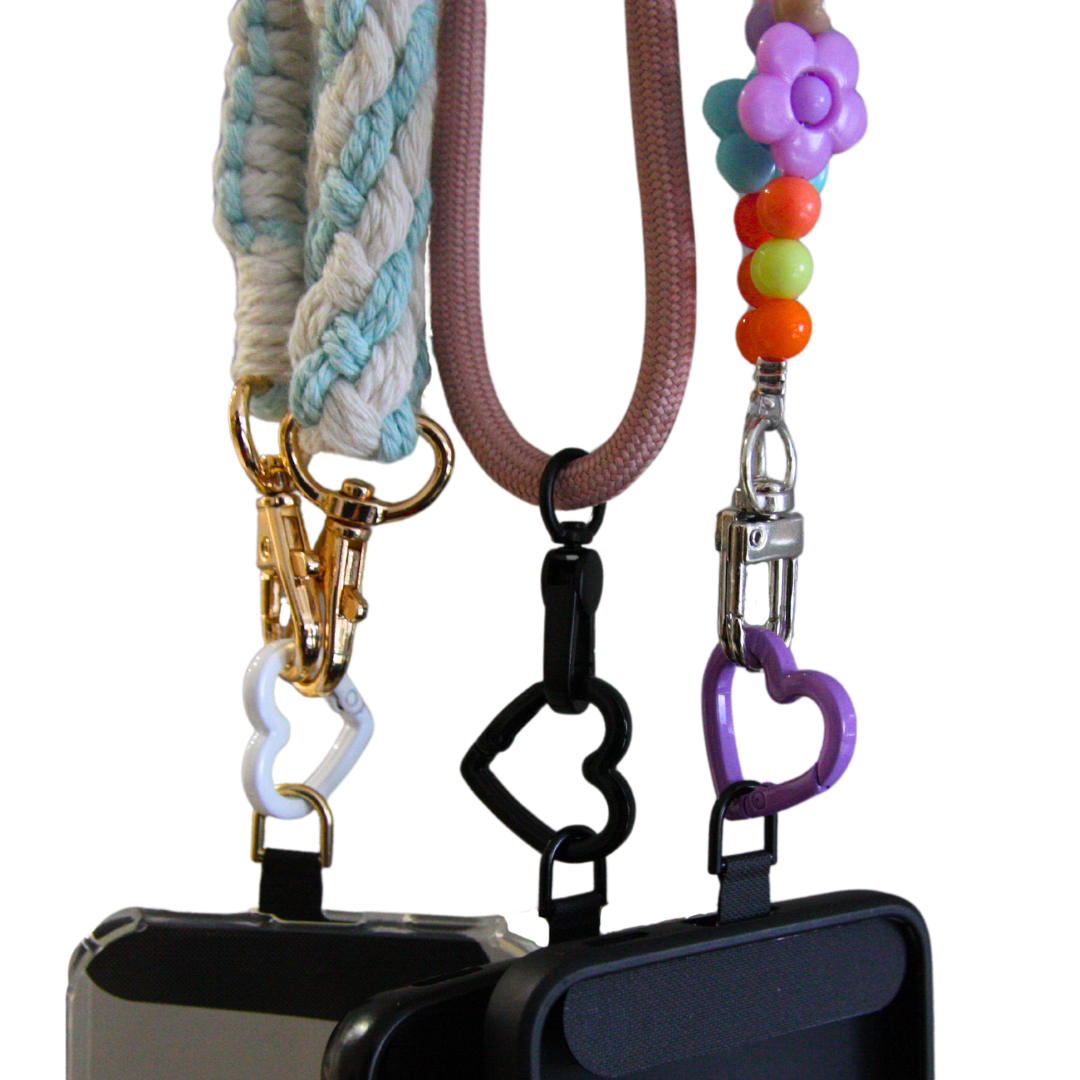 Three different crossbody phone straps connected with three different carabiner hearts.