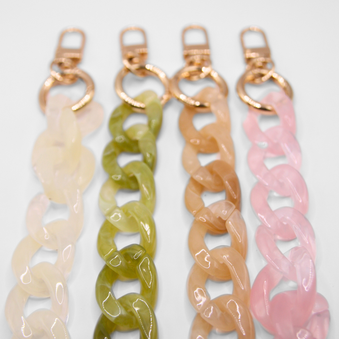 Focus and detailled photo of four different crossbody phone straps in four different colours.