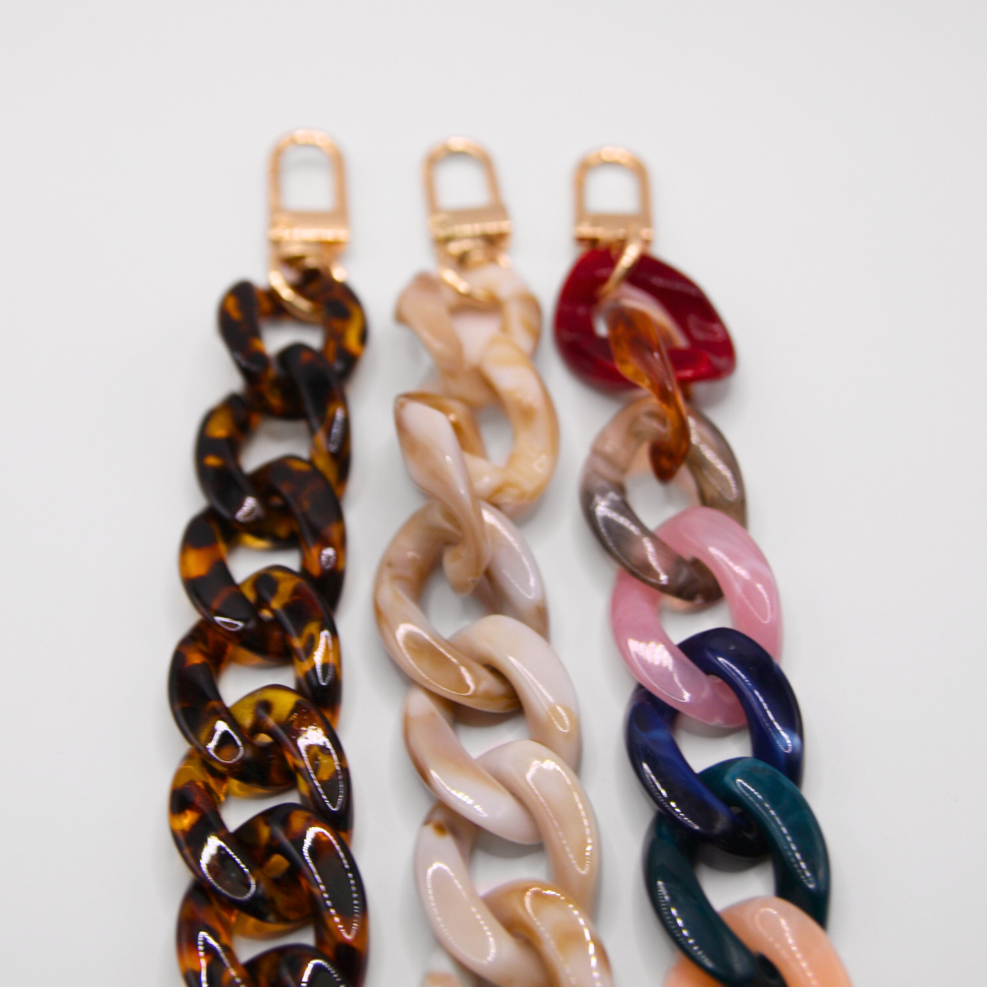 Close-up photo of three different crossbody phone straps in different colours.